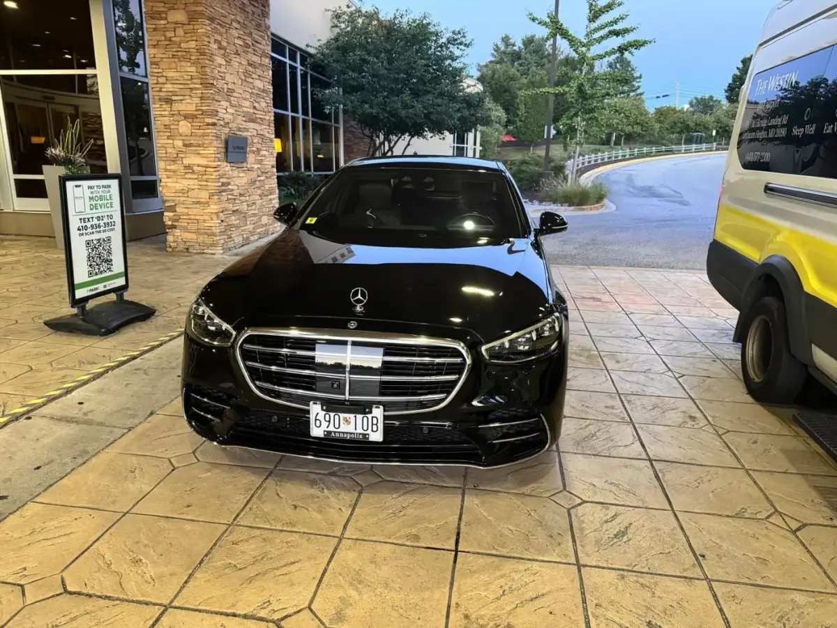 Mercedes-Benz S-Class chauffeur car waiting under the portico of a BWI airport hotel at night